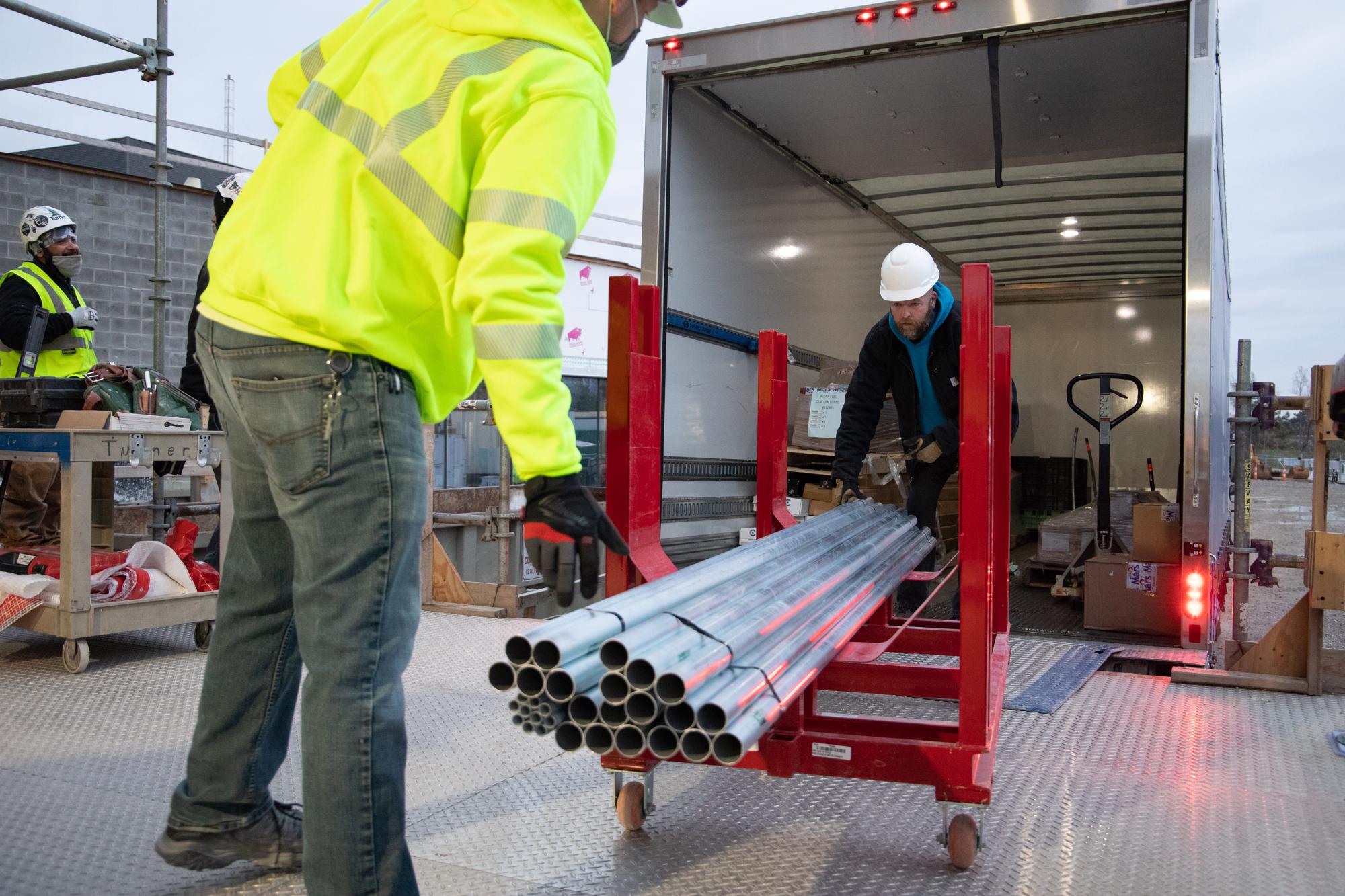 Mars Electric's delivery drivers rolling material onto a jobsite